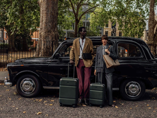a man and woman standing next to a car with luggage