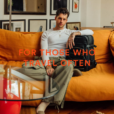a man sitting on a couch with a suitcase