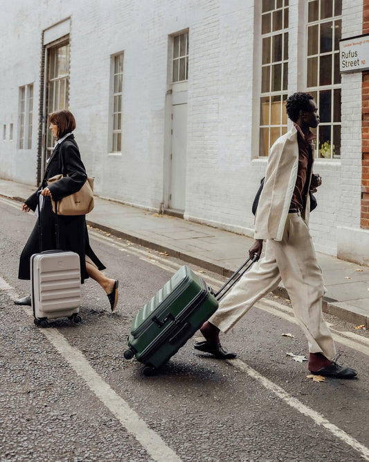 a man and woman walking with luggage