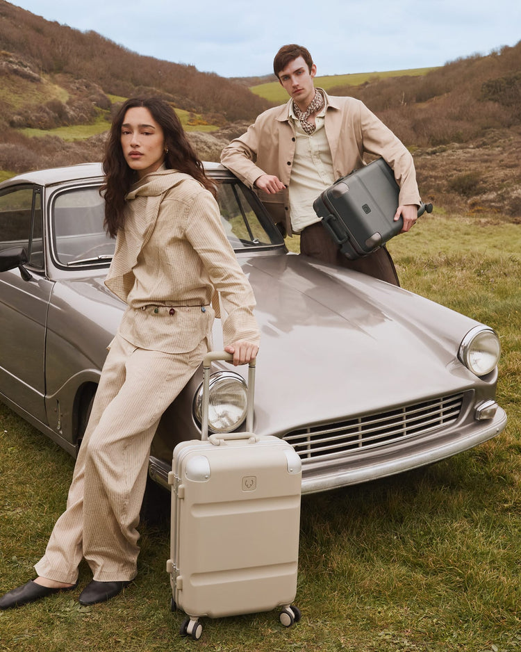 a man and woman with luggage on a car