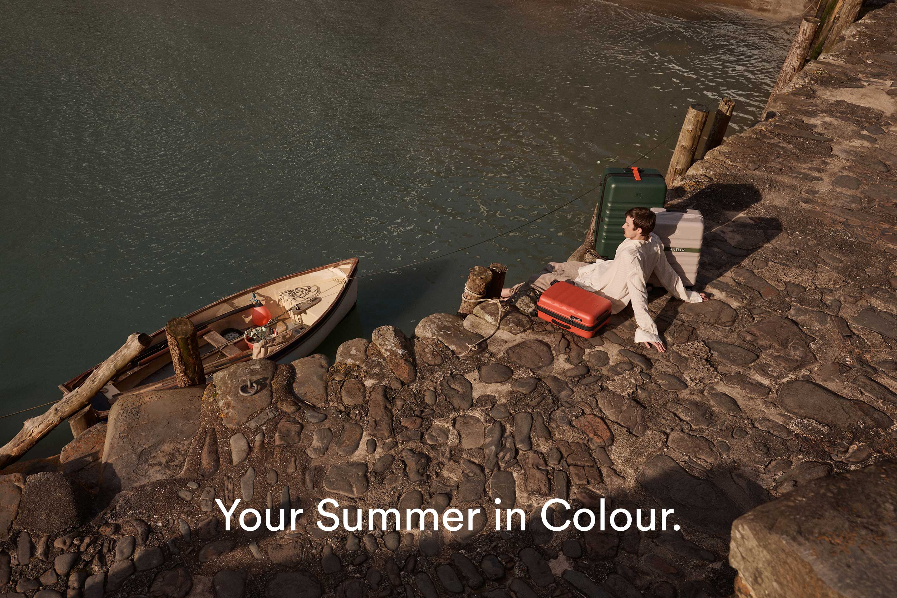 a man sitting on a stone path next to a boat