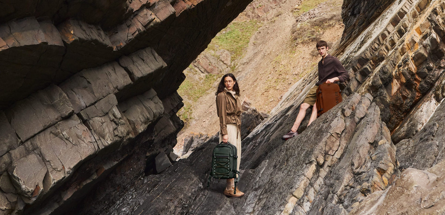 a man and woman standing on a rock