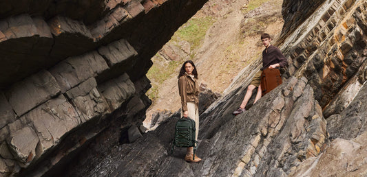 a man and woman standing on a rock