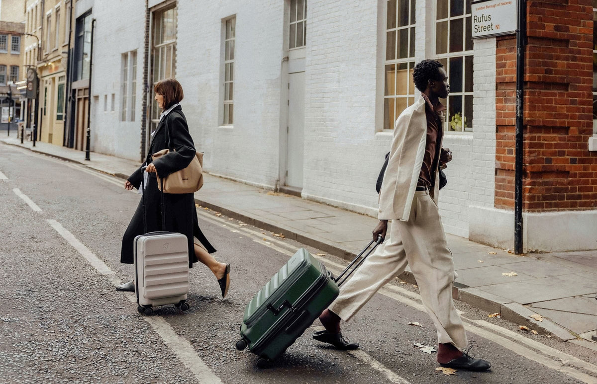 a man and woman walking with luggage