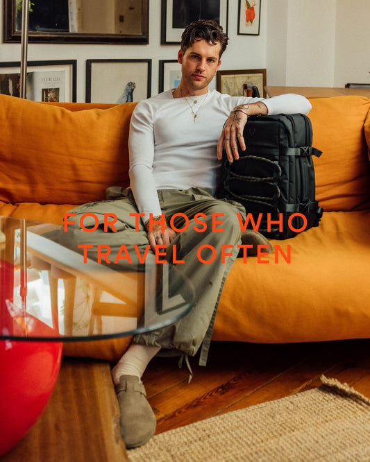 a man sitting on a couch with a backpack