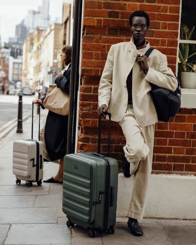 a man leaning against a wall with luggage