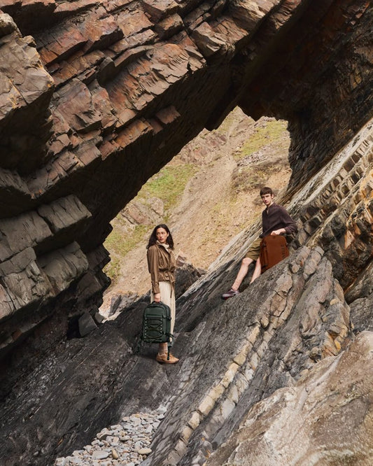 a man and woman standing on a rock