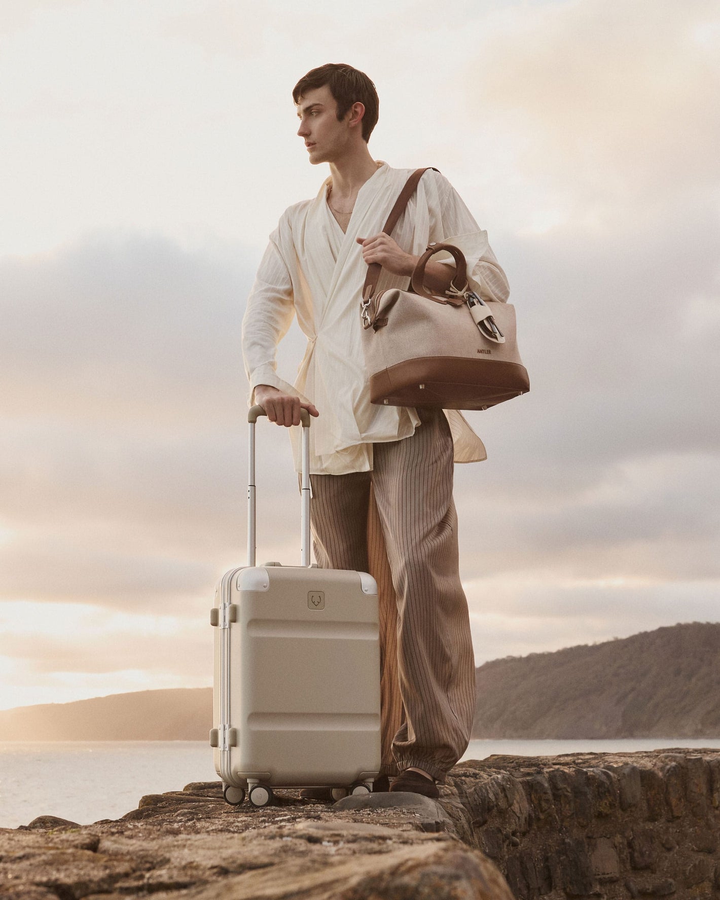 a man standing on a rock with a suitcase