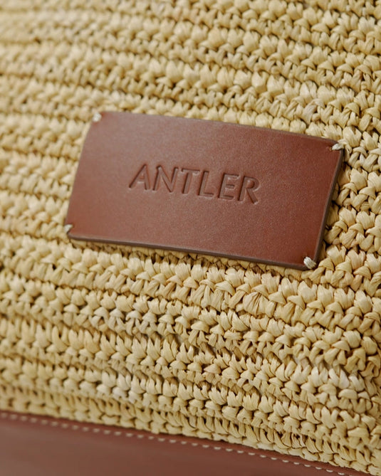 a brown leather tag on a woven bag