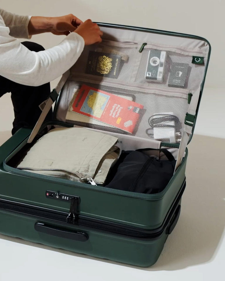 a person putting things in a suitcase
