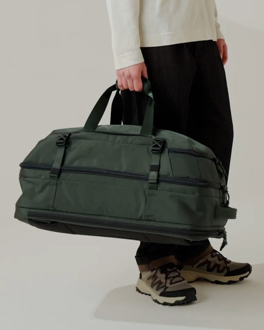 a person holding a large green bag