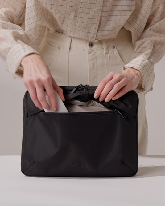 a person putting a piece of paper in a bag