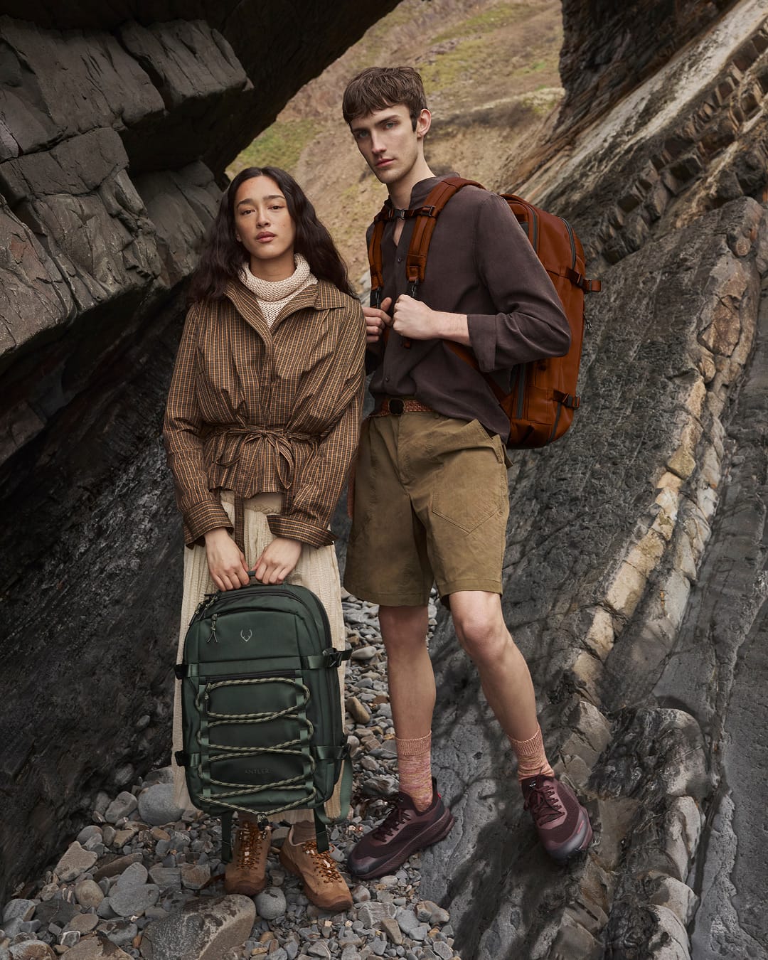 a man and woman standing on a rocky surface