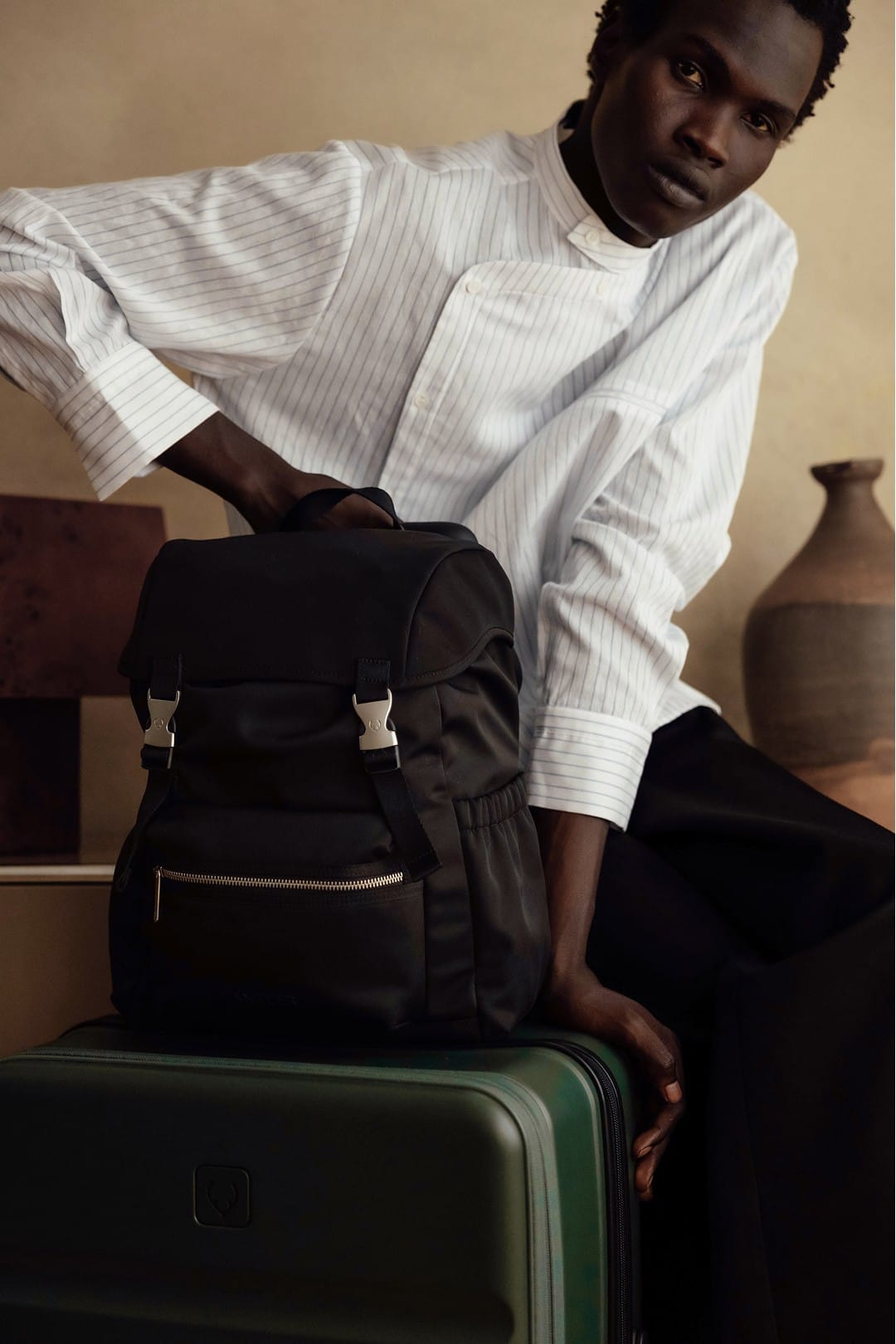 a man in a white shirt and black pants holding a backpack
