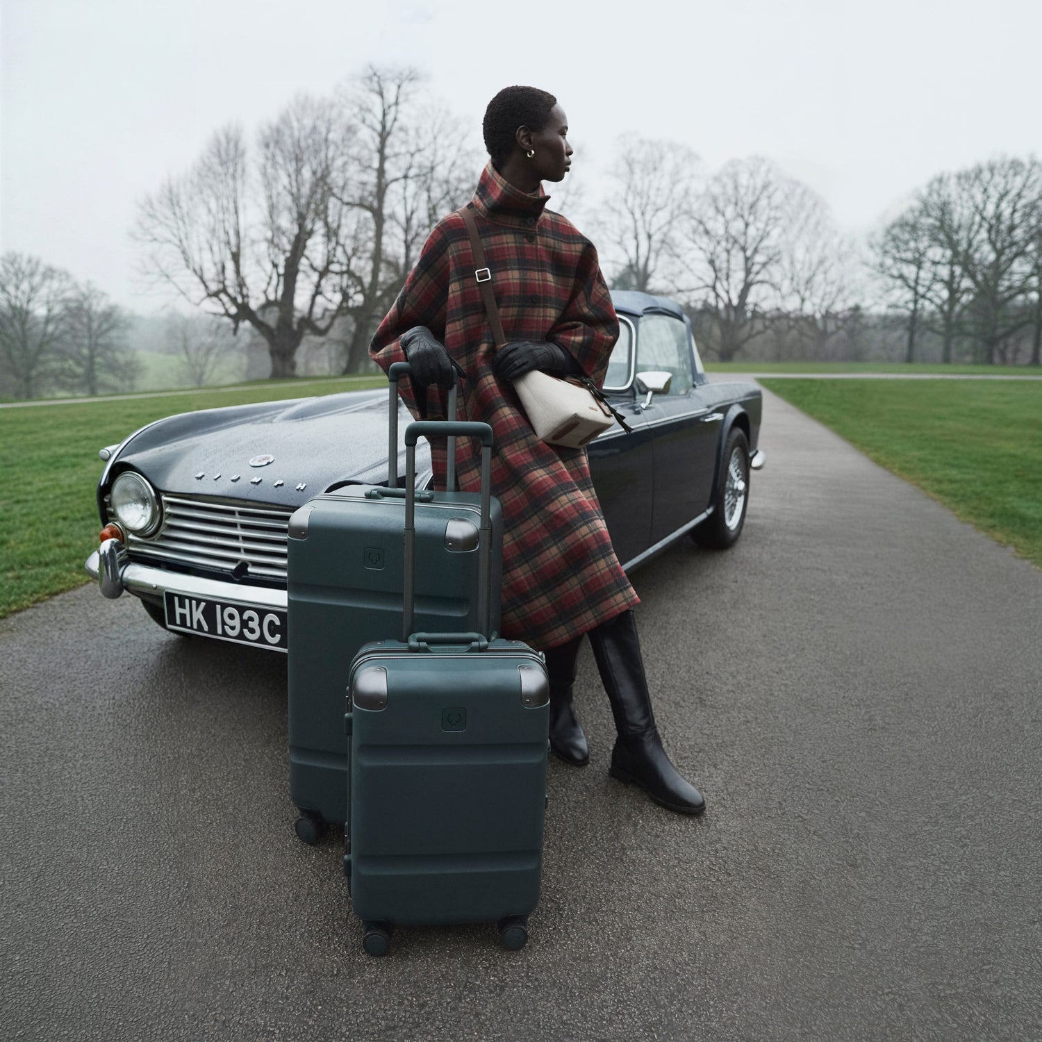 a woman standing next to a car with luggage