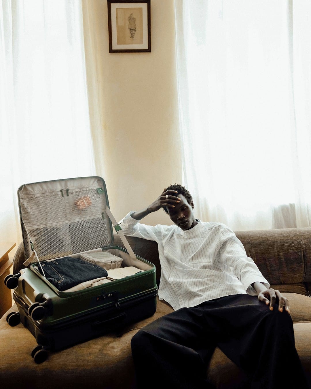 a man sitting on a couch with a suitcase