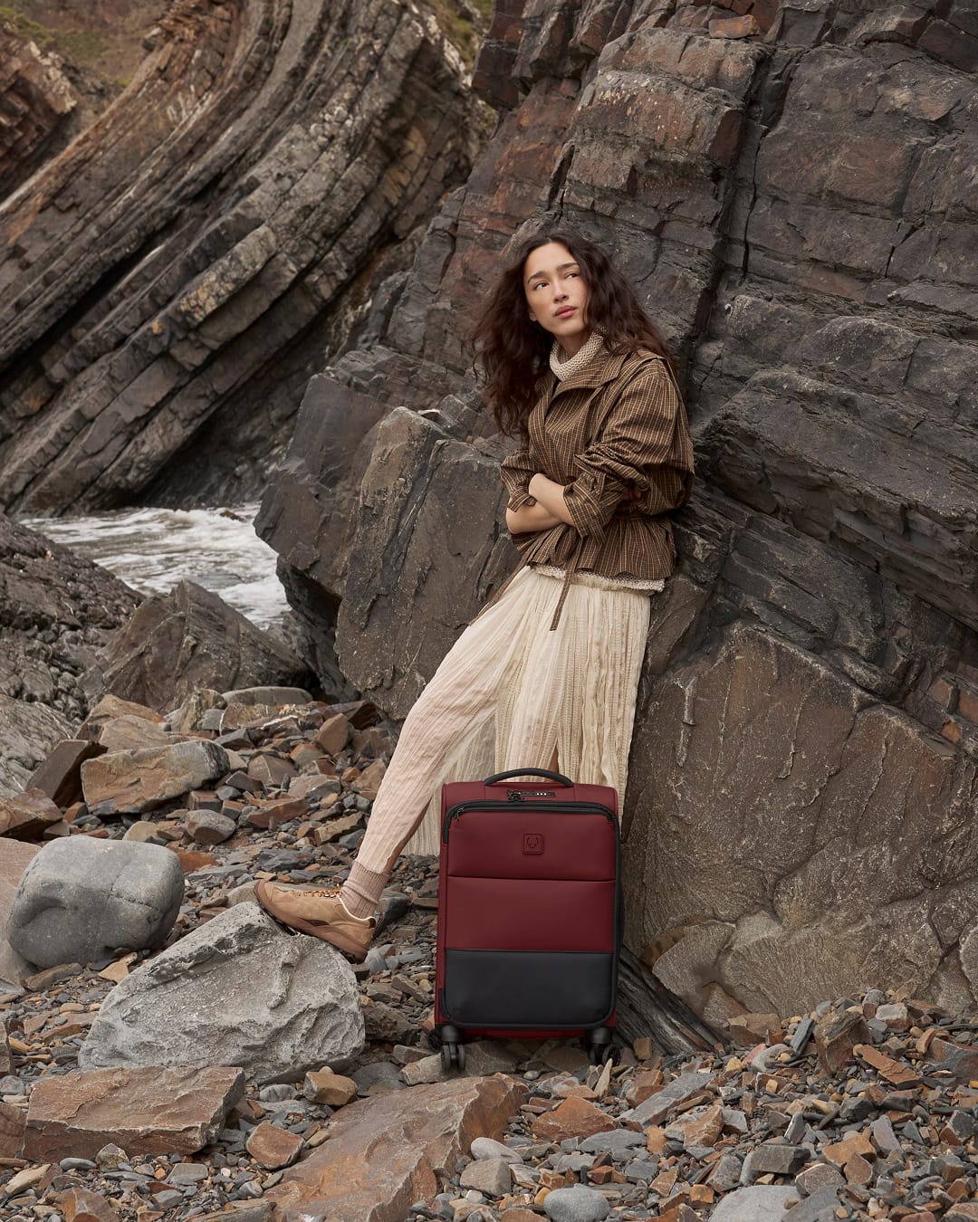 a woman leaning against a rock wall
