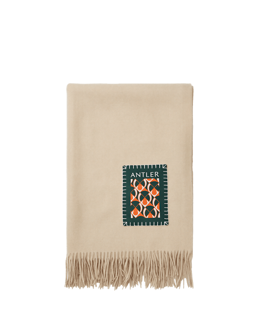 a beige blanket with fringe