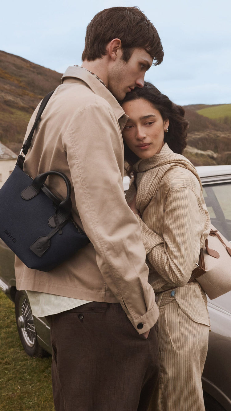 a man and woman hugging in front of a car