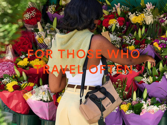 a woman standing in front of a bunch of flowers