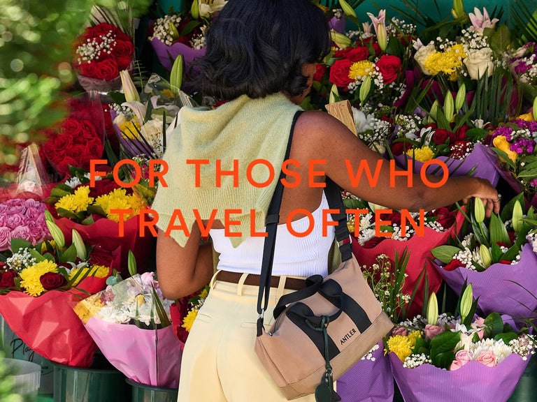 a woman standing in front of a bunch of flowers