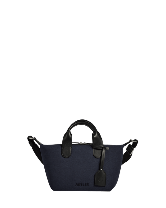 a blue woven bag with black handles