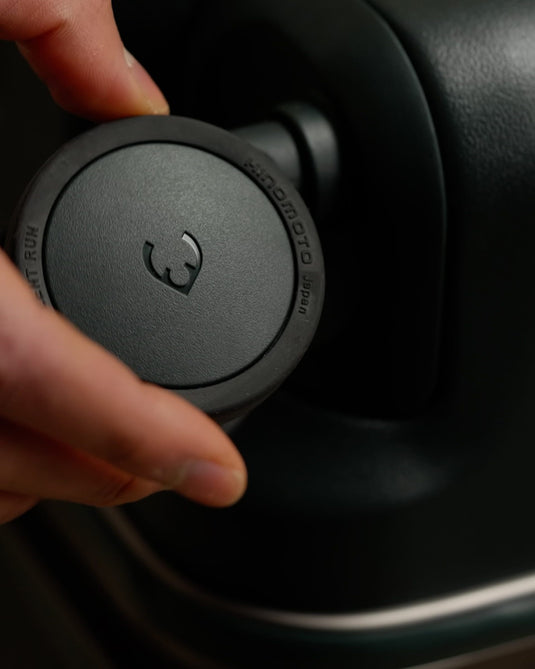 a hand holding a round black object