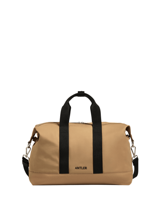 a tan bag with black straps