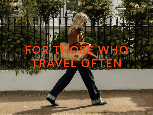 a woman walking on a sidewalk with a bag